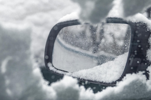 La morbida consistenza di neve e ghiaccio sul finestrino dell'auto è vista dall'interno in caso di maltempo. Messa a fuoco selettiva.