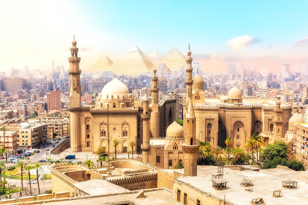 La moschea-madrasa del sultano Hassan e le piramidi sullo sfondo, bellissima vista del Cairo, Egitto.