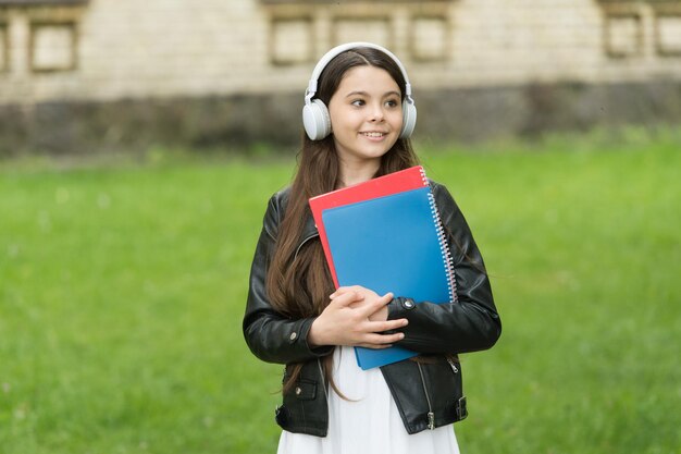 La musica è fantastica Il bambino fantastico ascolta la musica all'aperto La ragazza felice usa le cuffie per l'ascolto Scuola di lingue privata Strumenti tecnologici di apprendimento fantastici Vita moderna Abilità fantastiche da imparare