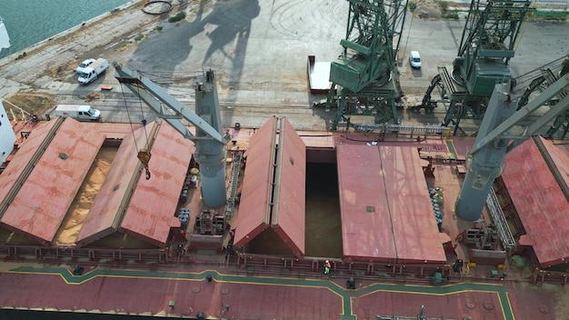 La nave da carico portarinfuse chiude la stiva piena di grano prima della spedizione vista aerea dall'alto