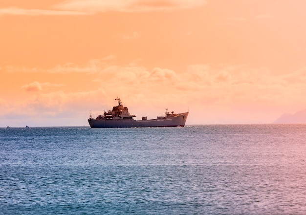 La nave militare sull'oceano all'alba