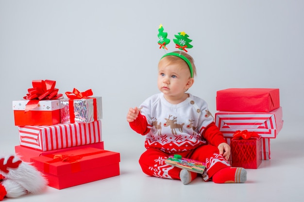 La neonata con i regali su un fondo bianco ha isolato il nuovo anno di natale