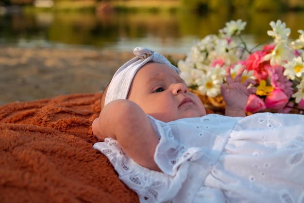 La neonata si trova sulla spiaggia in un vestito bianco
