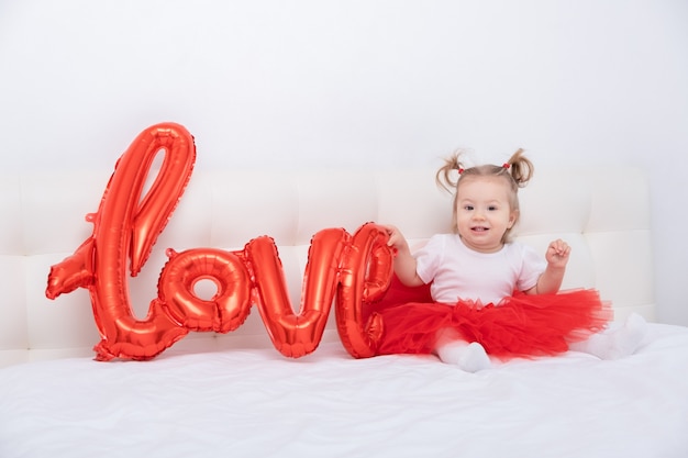 La neonata sveglia tiene la scritta amore da palloncini su fogli bianchi