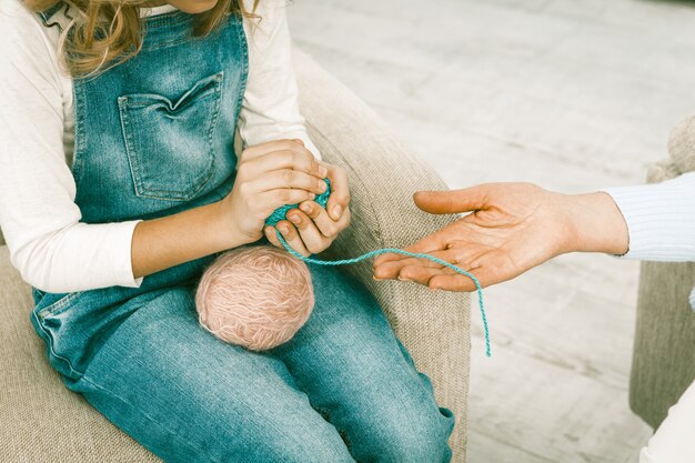 La nipote aiuta sua nonna a preparare il filo per lavorare a maglia