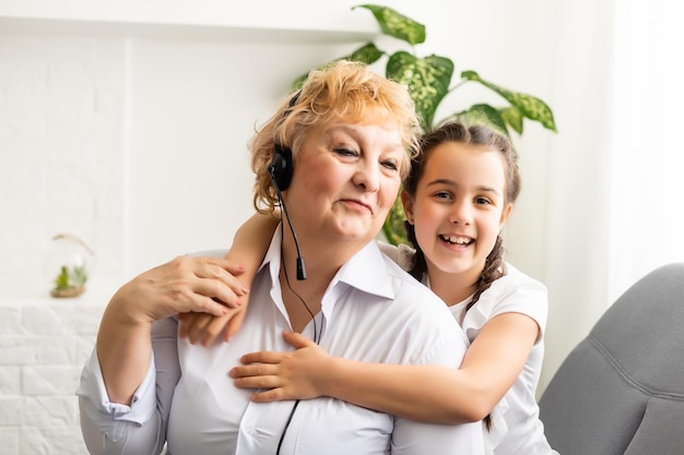 La nipote e la nonna ascoltano insieme le cuffie di musica mp3 sorridendo.