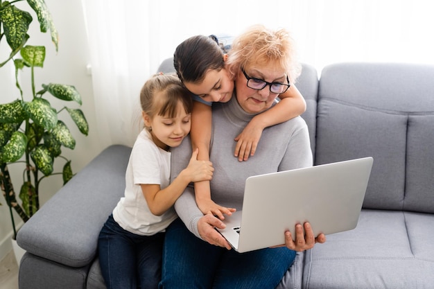 La nonna con le nipoti usa un computer.