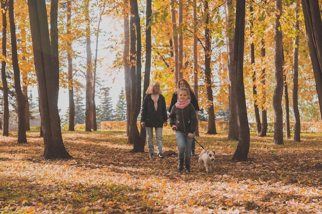 La nonna e la madre con la nipote camminano insieme nel parco autunnale e si divertono generazione