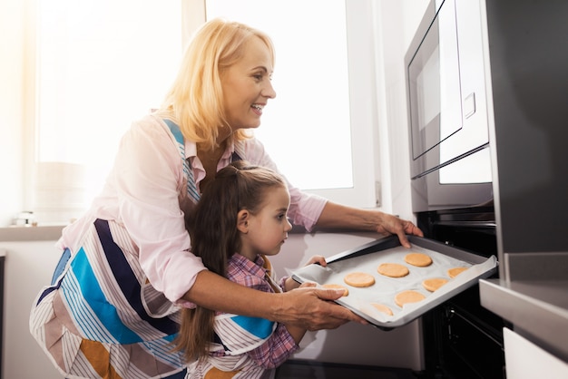 La nonna insegna alla ragazza a fare biscotti fatti in casa.