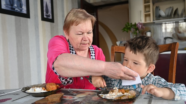 La nonna premurosa con suo nipote mangia.