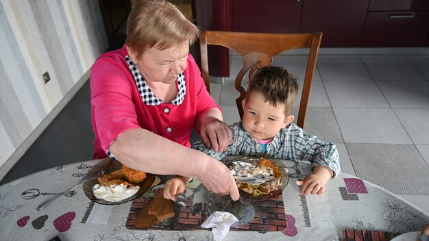 La nonna premurosa con suo nipote mangia.