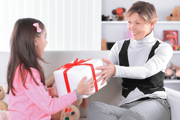 La nonna regala alla nipote una scatola con un regalo.