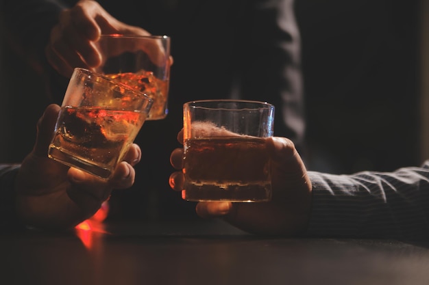 La notte della celebrazione versare il whisky in un bicchiere dare agli amici che vengono a festeggiare