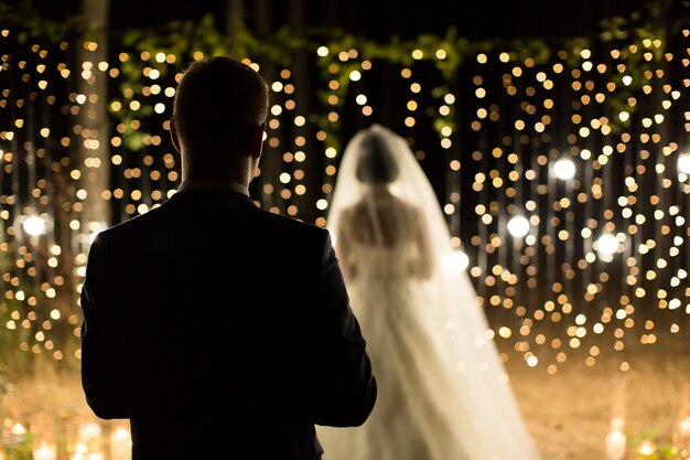 La notte della cerimonia nuziale. Incontro degli sposi, degli sposi nella pineta di conifere di candele e lampadine.