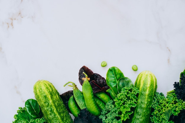 La pagina delle verdure verdi fresche su una priorità bassa di marmo, copia lo spazio, flay laici, vista superiore