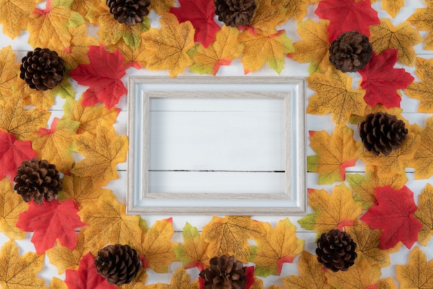 La pagina e l'autunno hanno asciugato le foglie su fondo di legno bianco. Autunno, autunno, vista dall'alto, copia spazio.