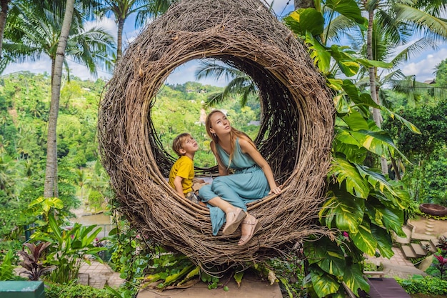 La paglia di tendenza di Bali nidifica ovunque la famiglia felice che si gode il viaggio intorno all'isola di bali in Indonesia