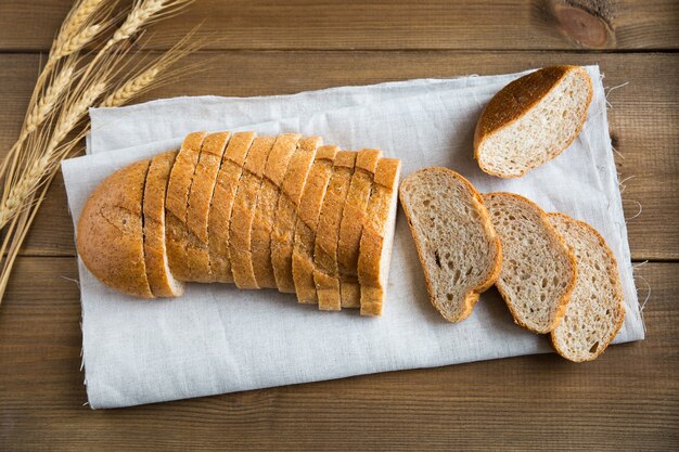 La pagnotta di grano con la crusca e tagliata a fette piatte adagiava su un tovagliolo di lino.