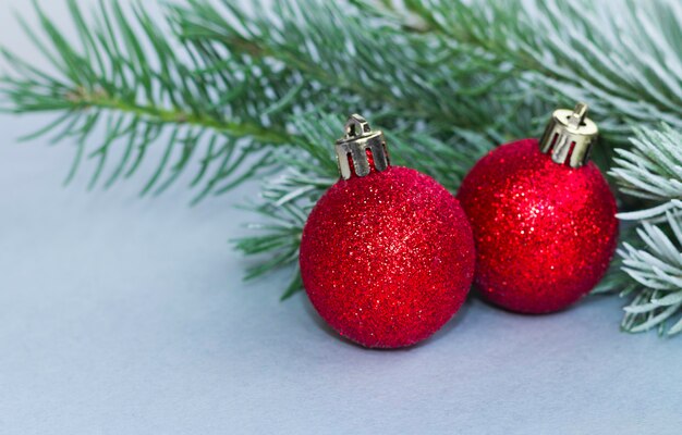 La palla rossa di Natale è appesa a un ramo di un albero di Natale Capodanno, auguri e biglietto di auguri.