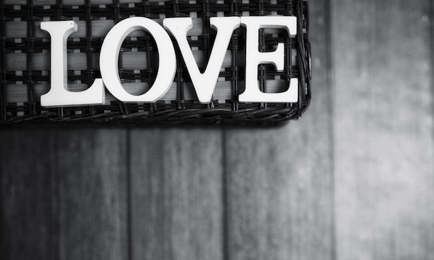 La parola amore composta da lettere di legno bianche su uno sfondo di legno