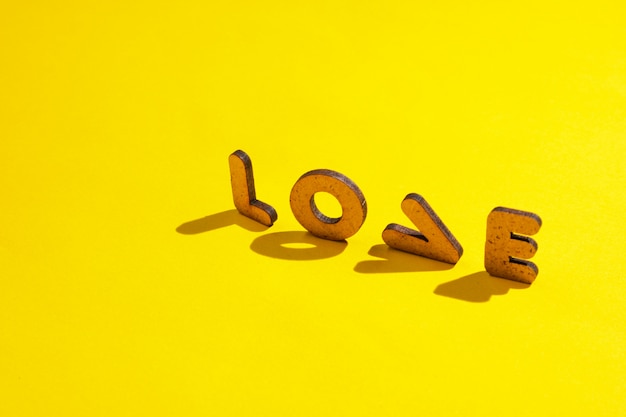 La parola amore dalle lettere su una superficie gialla