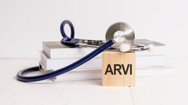 La parola ARVI è scritta su un cubo di legno vicino a uno stetoscopio su sfondo bianco ARVI abbreviazione di infezione virale respiratoria acuta Concetto medico