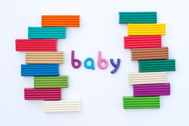 La parola bambino è fatta di plastilina multicolore con barre di plastilina attorno ai bordi su sfondo bianco