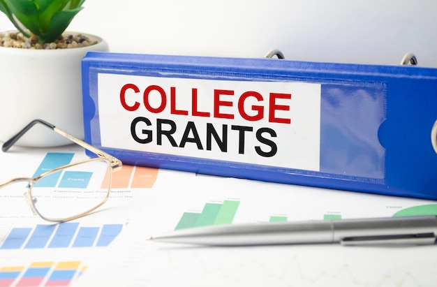 La parola college GRANTS è scritta su una cartella di file blu accanto ai documenti