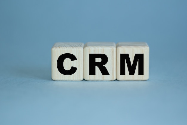 La parola CRM è scritta su cubi di legno. Può essere utilizzato per affari, marketing, concetto finanziario. Messa a fuoco selettiva.