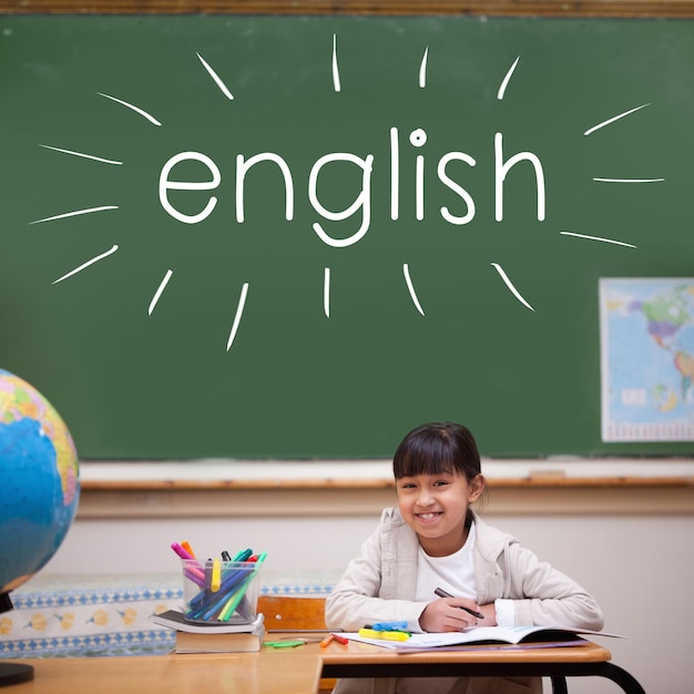 La parola inglese contro l'allievo carino seduto alla scrivania