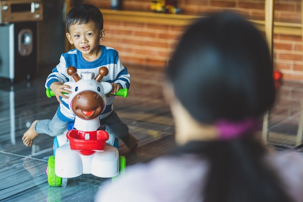 La parte della mamma single asiatica con il figlio sta giocando con il giocattolo insieme quando vivono nella casa del sottotetto