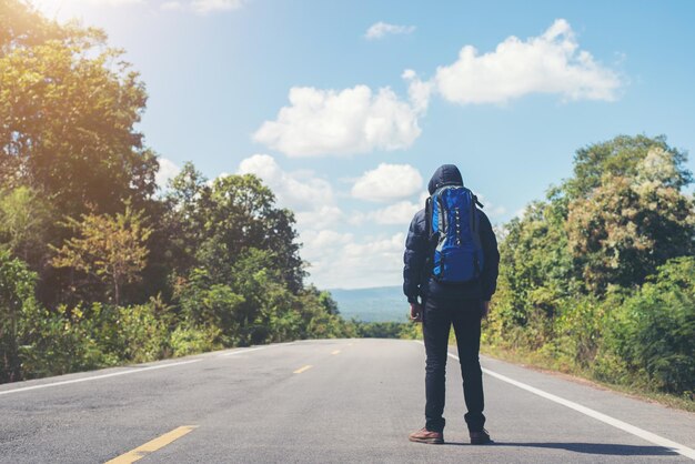 La parte posteriore di un escursionista che cammina sulla strada rurale in vacanza