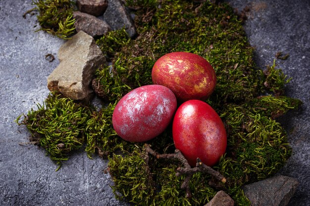La Pasqua ha dipinto le uova rosse su muschio