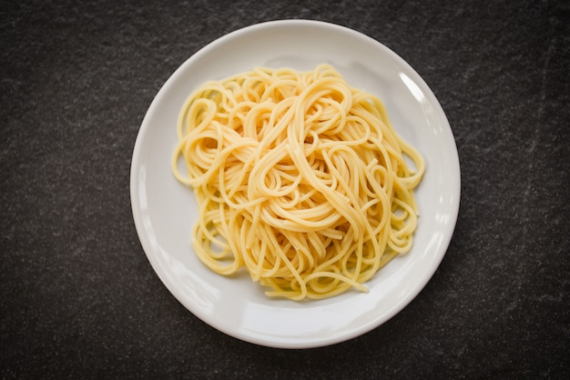 La pasta italiana degli spaghetti è servito sul concetto bianco dell'alimento e del menu degli spaghetti del piatto