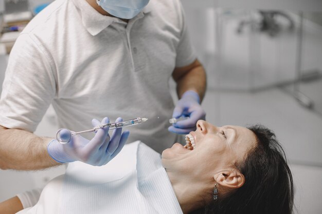 La paziente ha una visita odontoiatrica presso l'ufficio del dentista. La donna è bruna