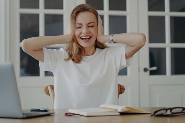 La pazza donna d'affari copre le orecchie e chiude gli occhi Concetto di rilassamento e di espressione delle emozioni