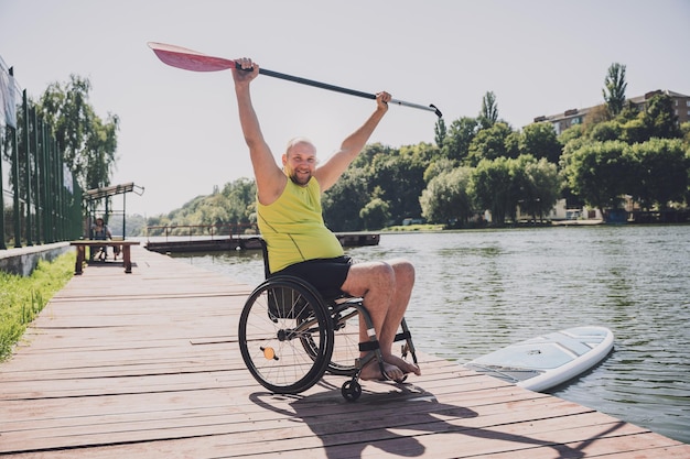 La persona con disabilità fisica che utilizza la sedia a rotelle sarà guidata su una tavola sup