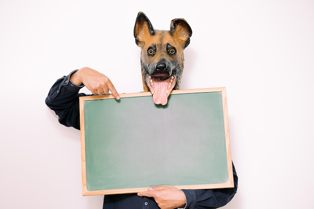 La persona con la maschera da cane felice indica un segno vuoto