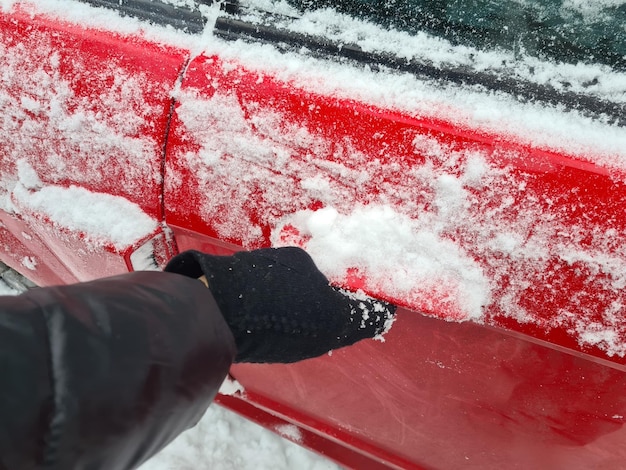 La persona con la portiera dell'auto congelata apre la portiera dell'auto o la serratura è bloccata