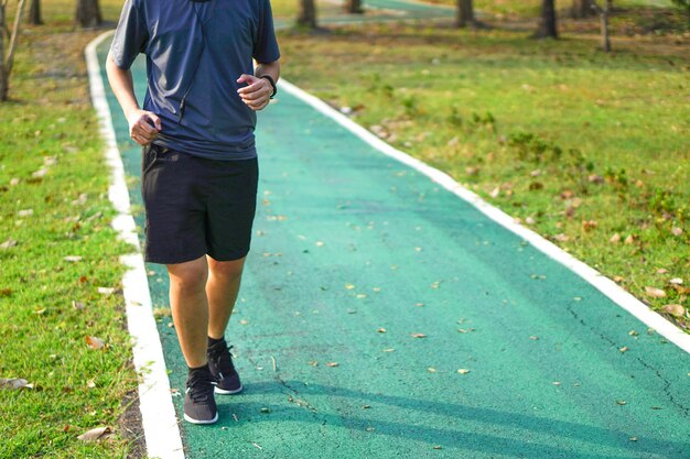 La persona si esercita facendo jogging o correndo nel parco insieme agli auricolari