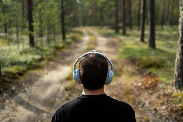 La persona sta ascoltando un audiolibro Musica calma e rilassante con le cuffie sta con la schiena