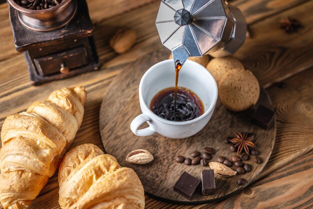 La persona sta versando caffè nero caldo fresco da una macchinetta del caffè geyser