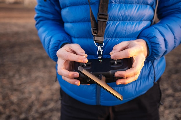 La persona tiene in mano il telecomando per il drone quadricottero. Tecnologia del dispositivo radio digitale per riprese video aeree