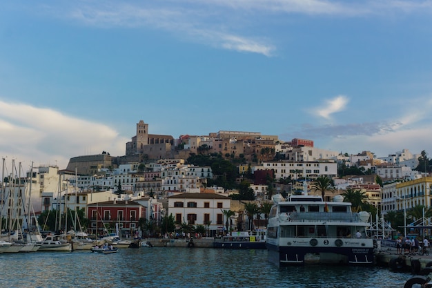 La pesca e le barche a vela sull'acqua di mare blu nella baia di Cala Vadella, isola di Ibiza, Spain