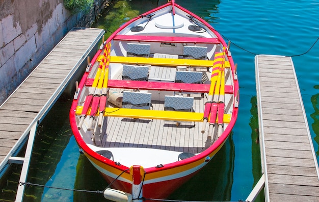 La piccola barca colorata parcheggiata sul molo in legno.