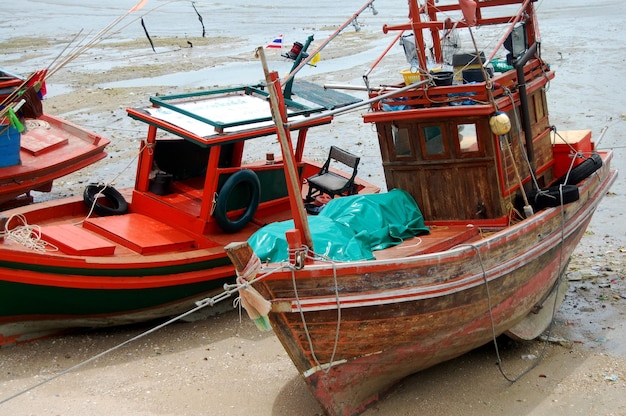 La piccola barca da pesca in legno locale tailandese galleggia nell'oceano del mare all'isola di Ko Sichang nel Golfo di Thailandia e aspetta la cattura di pesci e vita marina nella notte koh loy loi nella città di Sriracha a Chonburi Thailandia