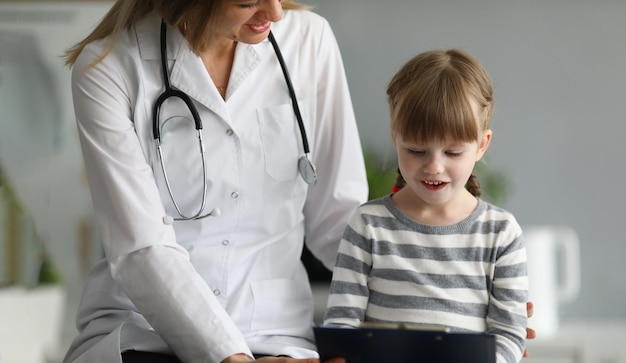 La piccola bella ragazza comunica con la dottoressa in clinica