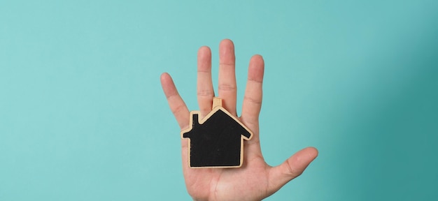 La piccola casa di legno nelle mani rappresenta concetti come l'amore familiare per la cura della casa