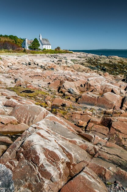 La piccola chiesa di PortauPersil dietro le rocce alla bassa marea Quebec Canada