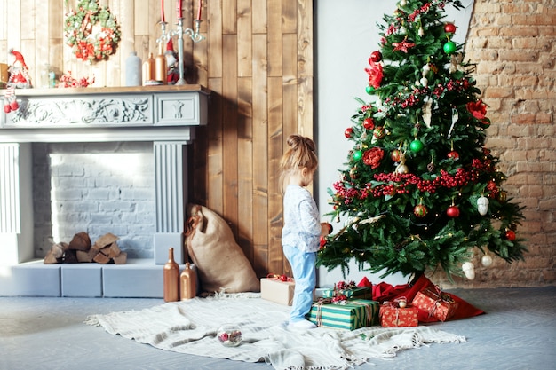 La piccola figlia decora l'albero di Natale. Il concetto di Chr